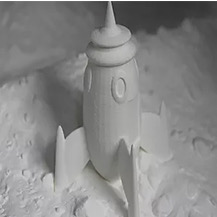 A freshly printed rocket still in its bed of nylon powder