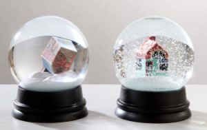 Two snow globes, each with a tiny 3D printed house inside